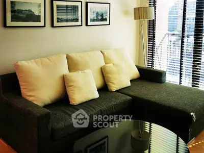 Stylish living room with modern sofa and city view through large windows.