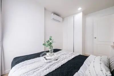 Cozy modern bedroom with stylish decor and ample natural light