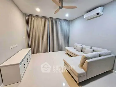 Modern living room with sleek white furniture and air conditioning