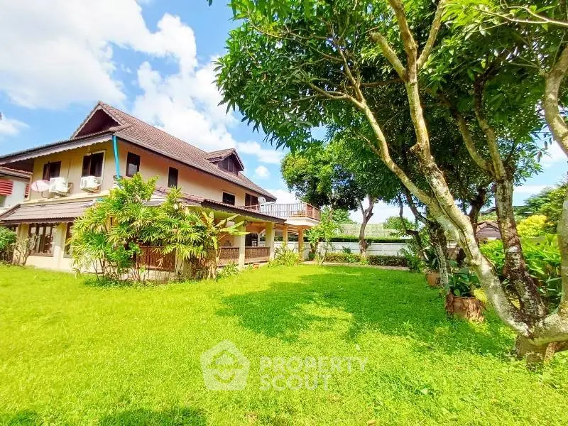 Charming two-story house with lush garden and vibrant greenery, perfect for serene living.