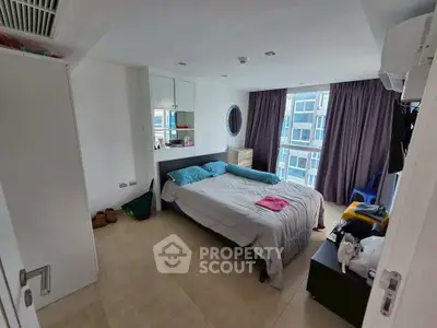 Spacious bedroom with modern decor and large window view