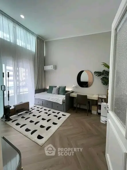 Modern living room with stylish decor, featuring a cozy seating area and a sleek workspace.