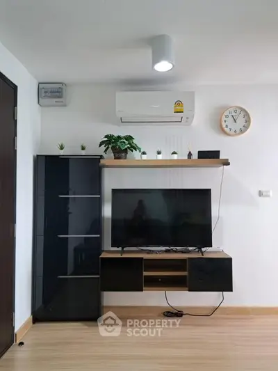 Modern living room with sleek TV setup and air conditioning, perfect for comfortable living.