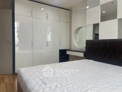 Modern bedroom with sleek white wardrobes and stylish headboard, perfect for urban living.