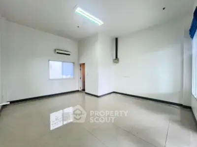 Spacious empty room with tiled flooring and air conditioning, ideal for customization.