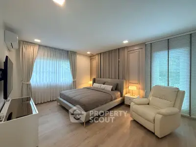 Luxurious bedroom with elegant decor and cozy lighting, featuring a plush bed and comfortable seating.