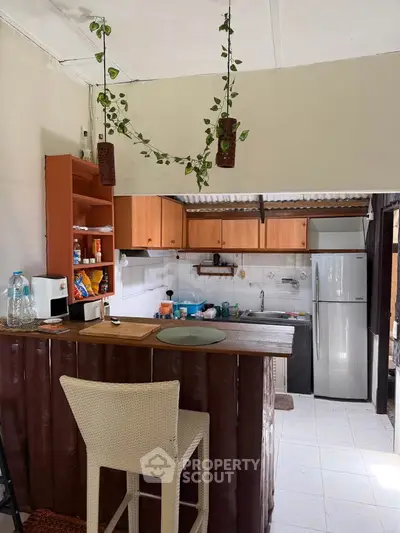 Charming rustic kitchen with open layout and breakfast bar, featuring wooden cabinets and modern appliances.