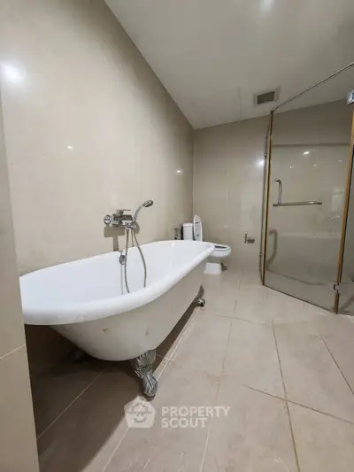 Luxurious bathroom with elegant freestanding bathtub and modern glass shower enclosure.