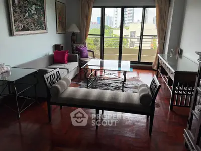 Spacious living room with elegant furniture and city view balcony.