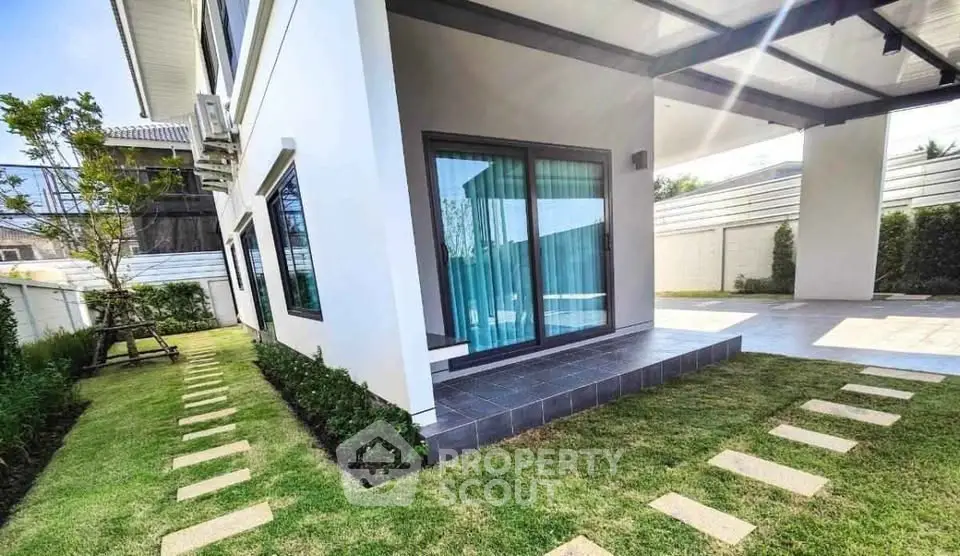 Modern home exterior with lush garden and stylish patio area