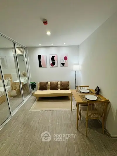 Modern living room with minimalist decor and dining area in a stylish apartment.