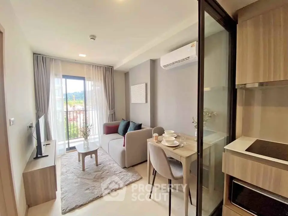 Modern living room with cozy sofa, dining area, and balcony view in a stylish apartment.