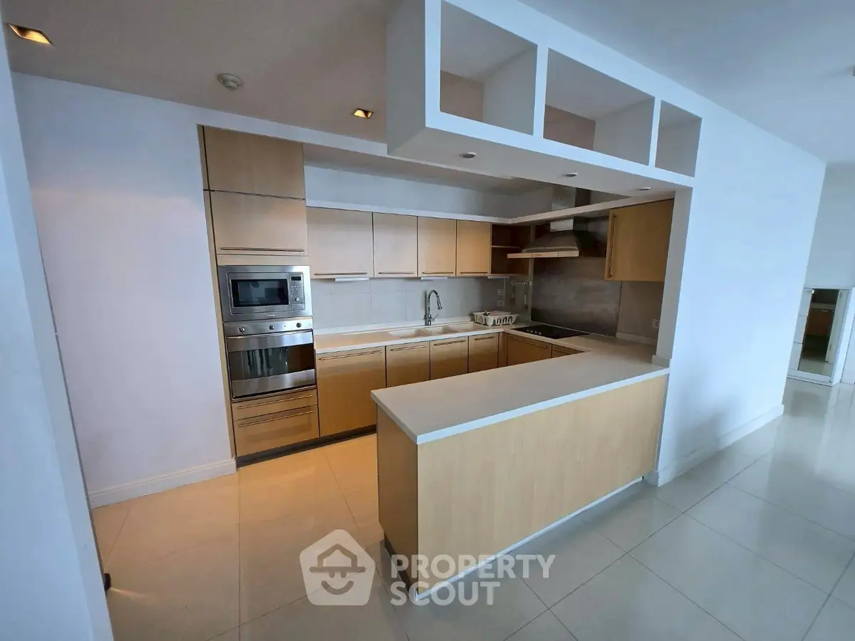 Modern kitchen with sleek cabinetry and built-in appliances in open layout