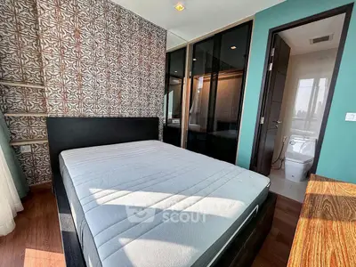 Modern bedroom with stylish decor and large windows offering natural light