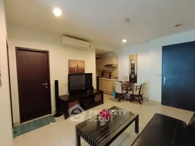 Modern living room with sleek furniture and open kitchen layout in a stylish apartment.