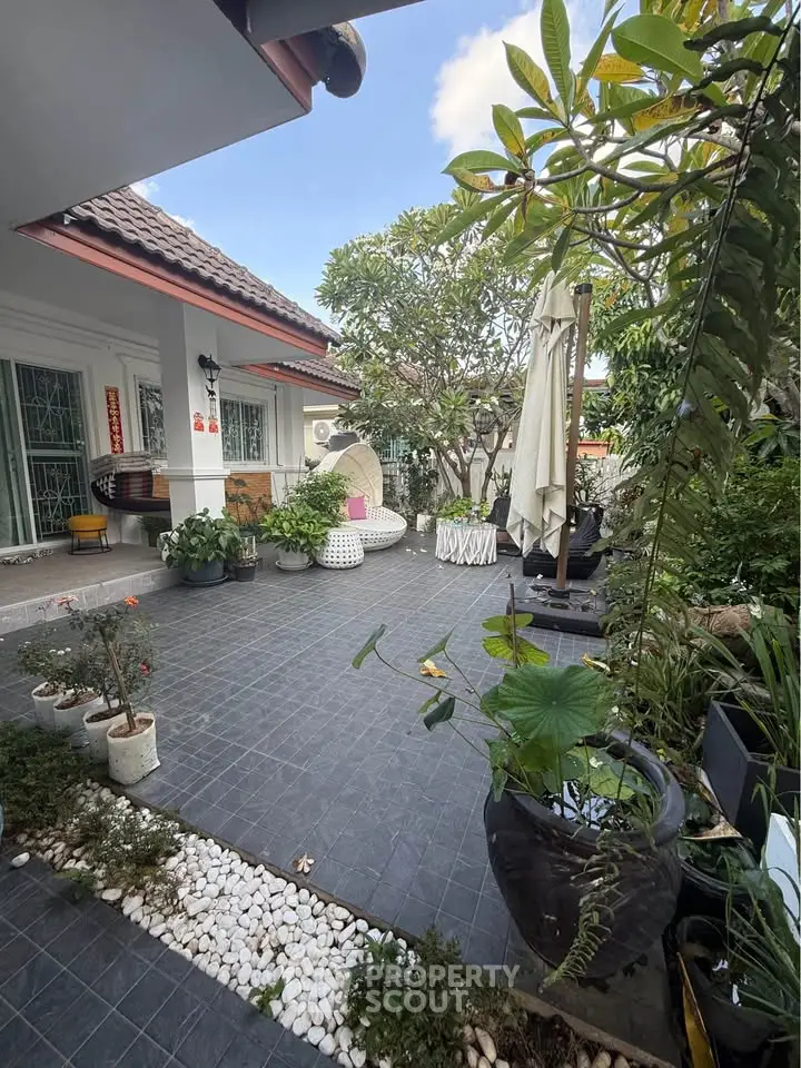Charming garden patio with lush greenery and stylish outdoor seating, perfect for relaxation and entertaining.