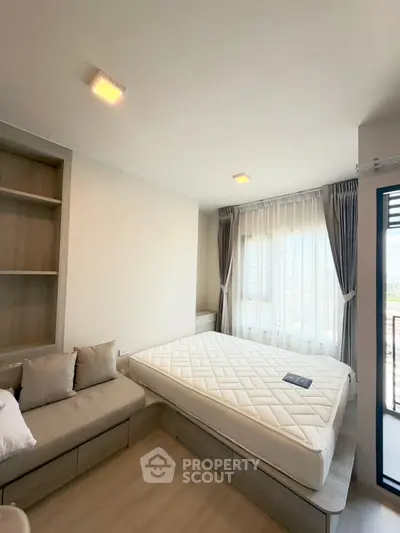 Modern bedroom with large window and built-in storage in a high-rise apartment.