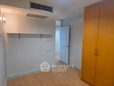 Spacious bedroom with wooden flooring and built-in wardrobe, perfect for modern living.