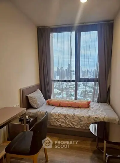Cozy bedroom with city view, featuring a single bed and modern furnishings.