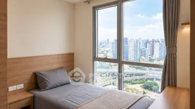 Modern bedroom with stunning city view from large window, featuring sleek wooden furniture and neutral decor.