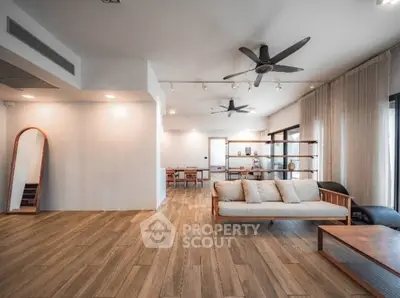 Spacious modern living room with wooden flooring and stylish furniture