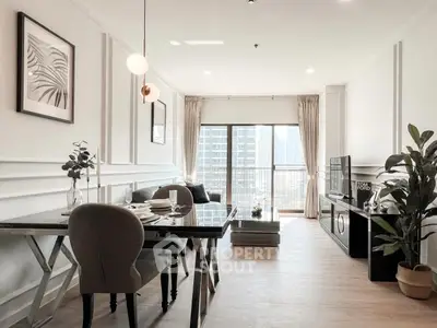 Elegant modern living room with dining area and city view, featuring stylish decor and natural light.