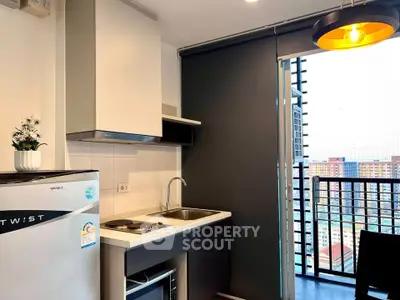 Modern kitchen with sleek appliances and balcony view in urban apartment