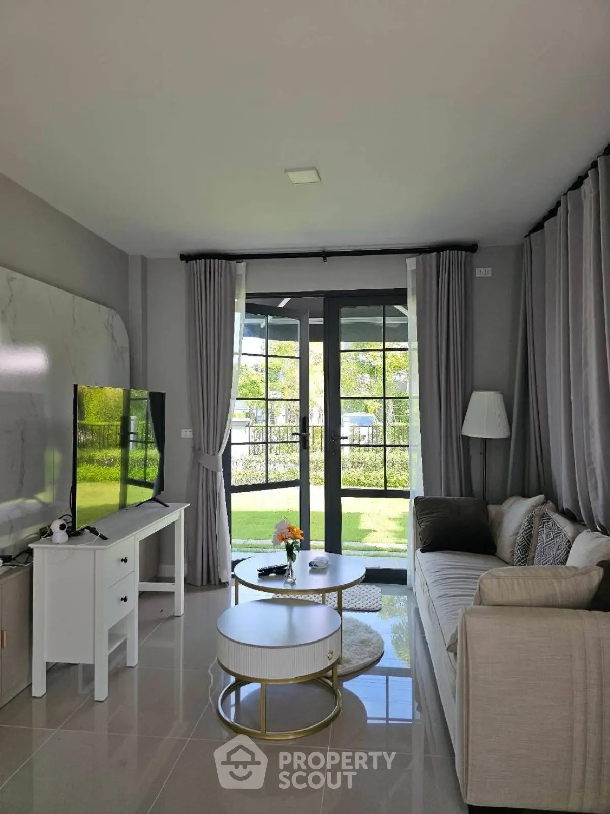 Elegant living room with modern decor and garden view through large windows.