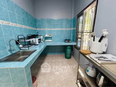 Spacious kitchen with turquoise tiles, modern appliances, and ample counter space.