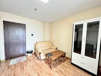 Cozy living room with beige sofa and wooden furniture, perfect for relaxation.