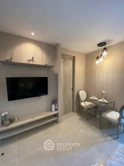 Modern living room with mounted TV, elegant dining set, and stylish lighting in a cozy apartment.