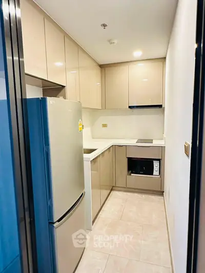Modern kitchen with sleek cabinetry and built-in appliances in a compact layout.