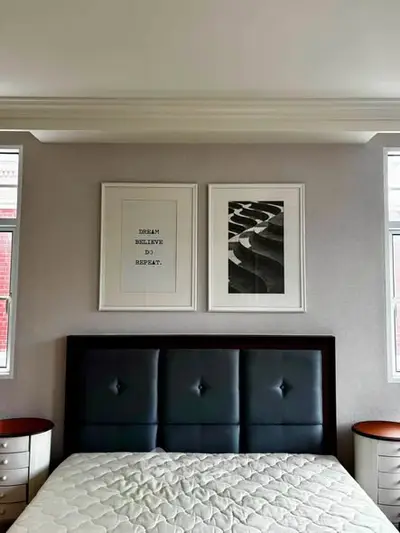Modern bedroom with stylish headboard and framed wall art, perfect for a cozy retreat.