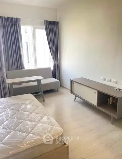 Cozy bedroom with modern furniture and natural light in a stylish apartment.