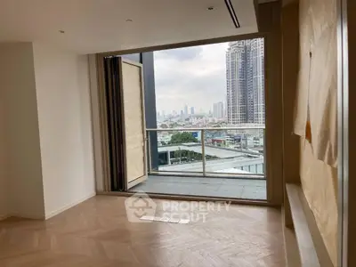 Spacious modern apartment with large windows and balcony offering stunning city views.