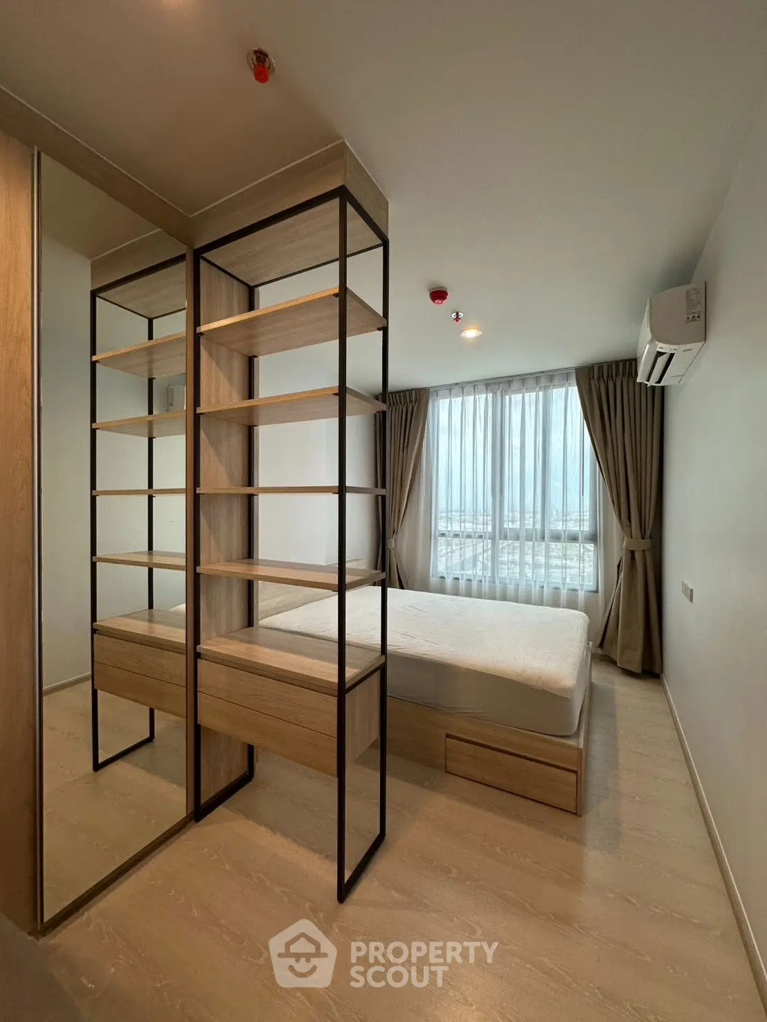 Modern bedroom with large window and stylish shelving unit