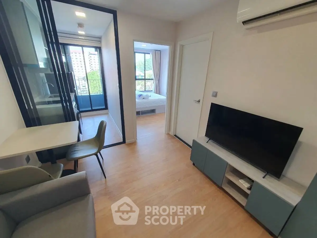 Modern apartment interior with open layout, featuring a cozy living area and bedroom with balcony view.