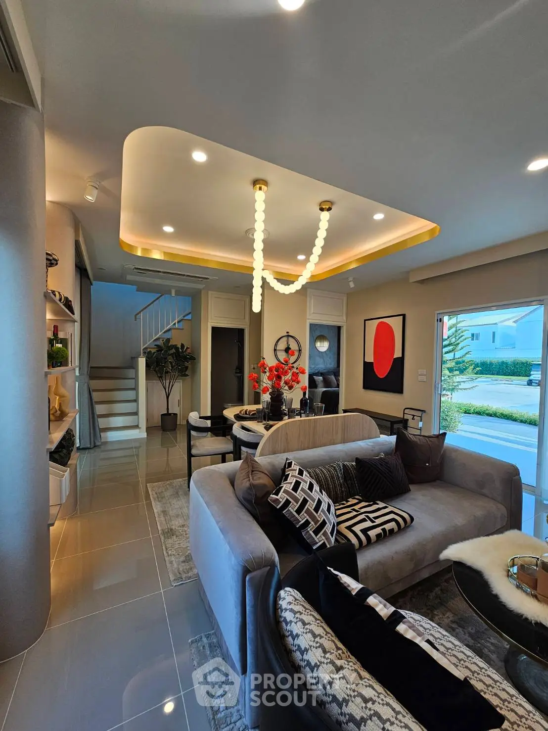 Luxurious living room with modern decor and elegant lighting, featuring plush seating and stylish artwork.