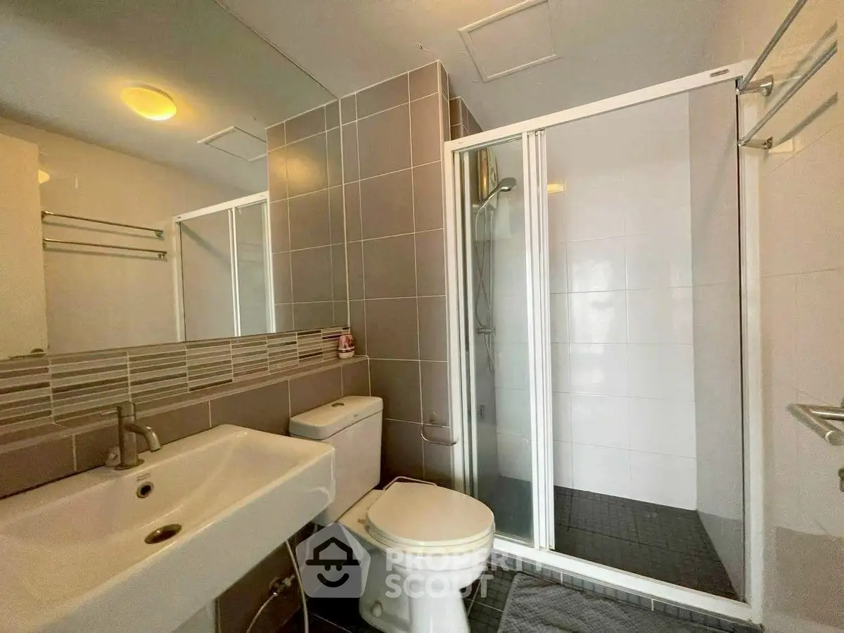 Modern bathroom with sleek shower and stylish sink in contemporary apartment.
