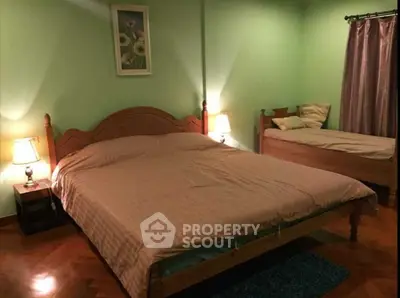 Cozy bedroom with double and single beds, warm lighting, and elegant decor.