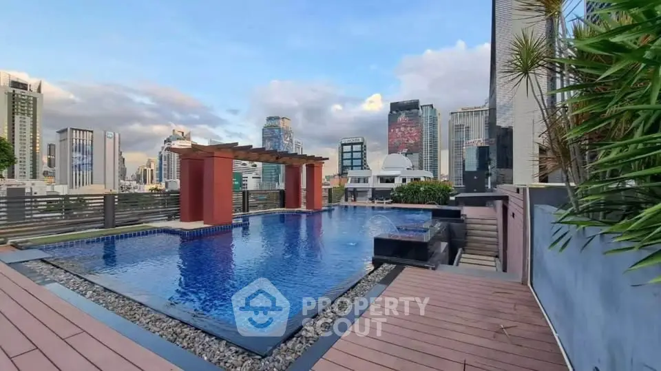 Luxurious rooftop pool with stunning city skyline views in modern urban setting.
