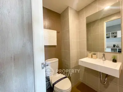 Modern bathroom with sleek fixtures and neutral tiles in a contemporary home.