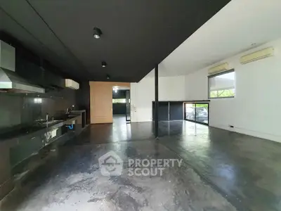 Spacious modern open-plan living area with sleek black and white design.