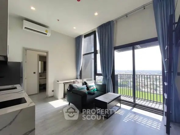 Modern living room with balcony and panoramic view, featuring sleek furniture and abundant natural light.
