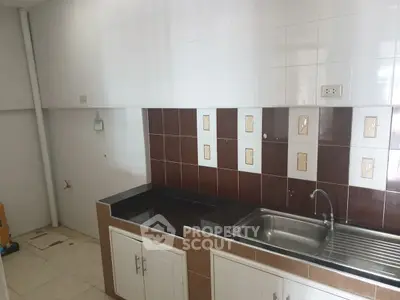 Spacious kitchen with sleek countertops and modern sink in a bright setting.