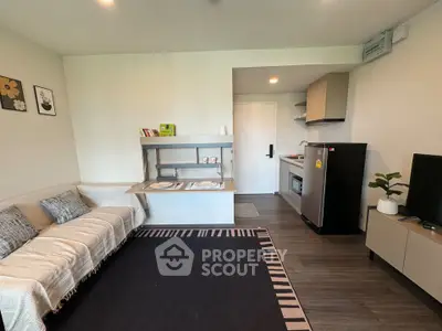 Modern living room with cozy sofa, stylish kitchen, and sleek appliances in open layout apartment.