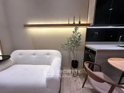 Modern living room with stylish furniture and sleek kitchen appliances in a cozy apartment setting.