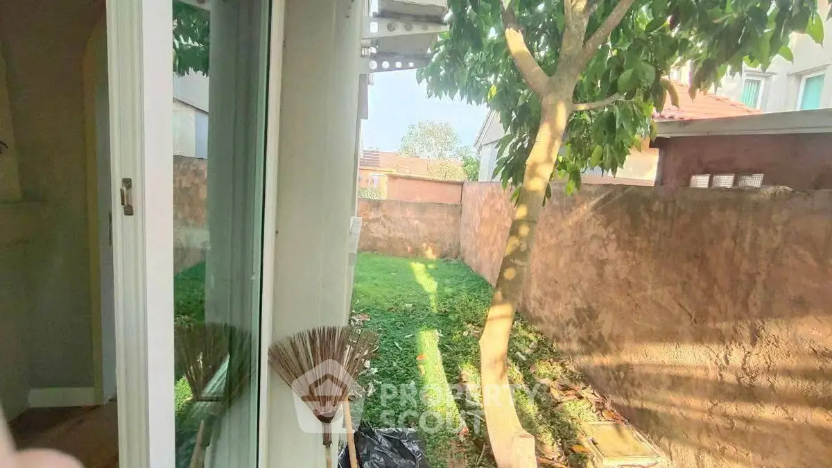 Charming garden view from a cozy home with lush greenery and natural light.