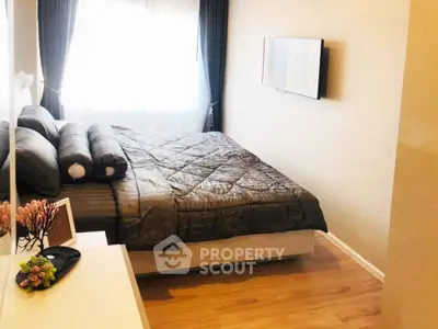 Cozy bedroom with modern decor and natural light, featuring a wall-mounted TV and elegant bedding.