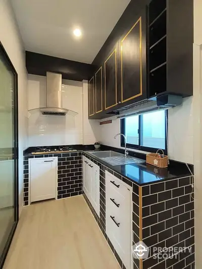 Modern kitchen with sleek black cabinets and gas stove in stylish apartment